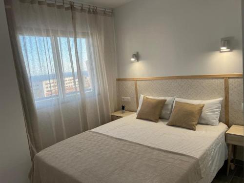 een slaapkamer met een bed met een groot raam bij Playa Paraiso Apartment in Adeje