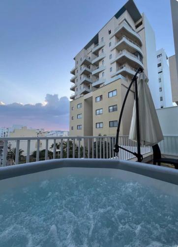 a balcony with a swimming pool and a building at Sea Breeze, Spacious 2-Bedroom LUX Seaside Apartments in St. Paul's Bay
