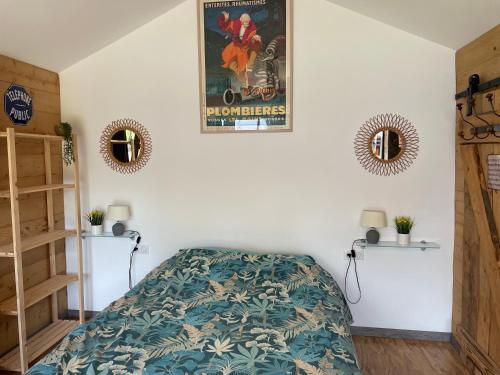 - une chambre avec un lit et une affiche murale dans l'établissement Gîte à broc à 5 minutes de Plombières les Bains, à Plombières-les-Bains