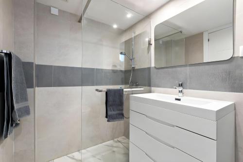 Un baño con un lavabo blanco y un espejo. en @SeaFront, en Sitio de Calahonda