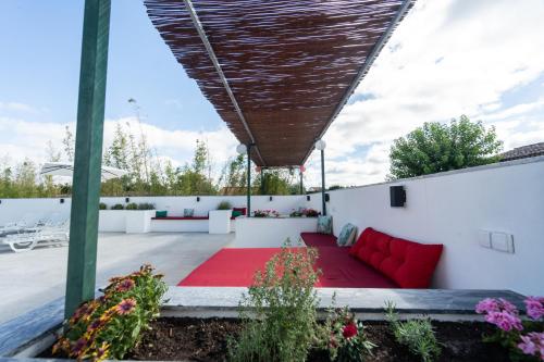 a patio with a red couch on a white wall at Quinta do lagar in Chamusca