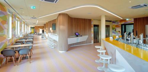 a waiting room with a row of chairs and a bar at Prize by Radisson, Münster City in Münster