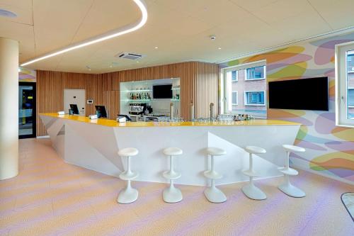 a lobby with a bar with stools in front of it at Prize by Radisson, Münster City in Münster