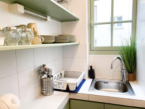 une cuisine avec un évier et une fenêtre dans l'établissement une pièce Cosy à 5 Min de la Tour Eiffel à pied, à Paris