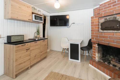 a kitchen and living room with a brick fireplace at BohoSauna in Oulu
