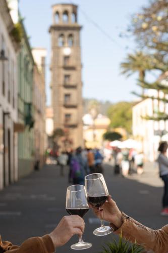 two people holding glasses of wine on a street at La Casa de La Camelia in La Laguna