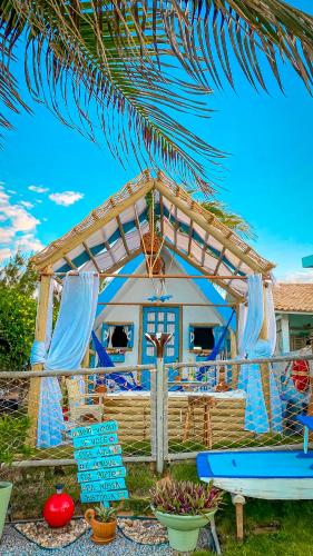 a house with blue chairs and a pergola at Raio de Sol Residence in Canoa Quebrada