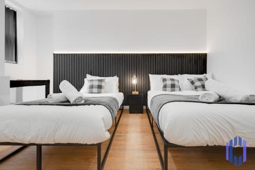 two twin beds in a room with at Sophisticated & Stylish Flat near Manchester Airport - Sleeps 9 in Manchester