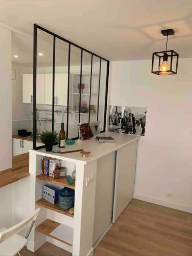 une cuisine avec un comptoir blanc avec une étagère dans l'établissement Lovely appartement in Montmartre, à Paris