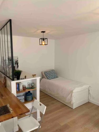 une chambre avec un lit, une table et une chaise dans l'établissement Lovely appartement in Montmartre, à Paris