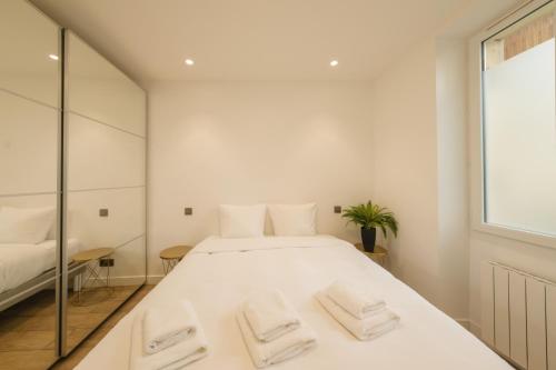 une chambre avec un grand lit blanc avec deux serviettes dans l'établissement Cosy apartment 3P - Place de l'Etoile, à Paris