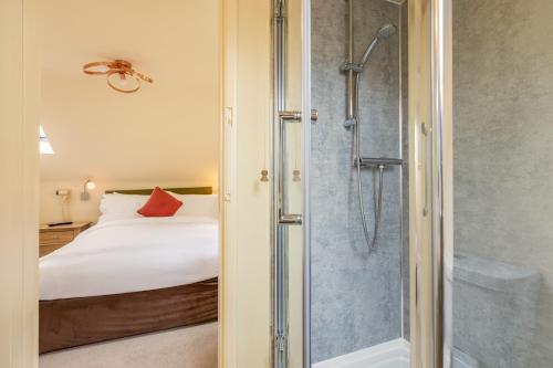 ein Schlafzimmer mit einem Bett und einer Dusche in einem Zimmer in der Unterkunft Valley View Farm Holiday Cottages in Helmsley