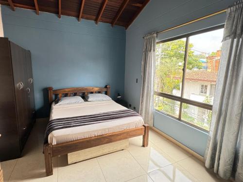 a bedroom with a bed and a large window at Apartamento Relax in Medellín