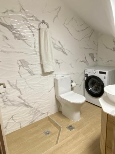 a bathroom with a toilet and a washing machine at Olia Residences Lesvos in Mytilini