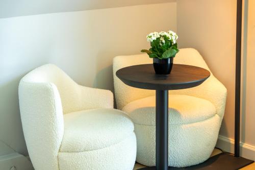 two chairs and a table with a vase of flowers at L’Impasse in Nampty