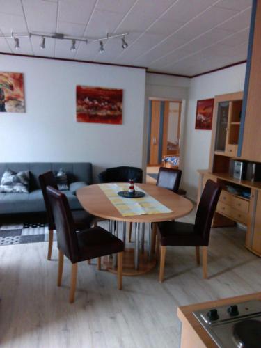 una sala de estar con una mesa y sillas en Ferienhaus Riebe, en Stollhamm
