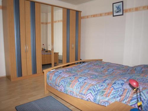 Un dormitorio con una cama con cabecero de madera. en Ferienhaus Riebe, en Stollhamm