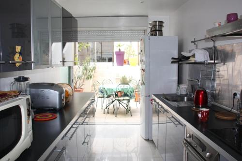 une cuisine avec un évier et un plan de travail dans l'établissement PETITE MAISON D'HÔTE et SON PATIO au PIED DE NOTRE-DAME, à Marseille