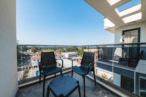 two chairs on a balcony with a view of a city at M&N Holiday Resort in Ulcinj