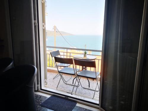 a view of the ocean from a balcony with a table and chairs at Sea View Apartment with 3 Bedrooms in Amfilochia in Amfilochía