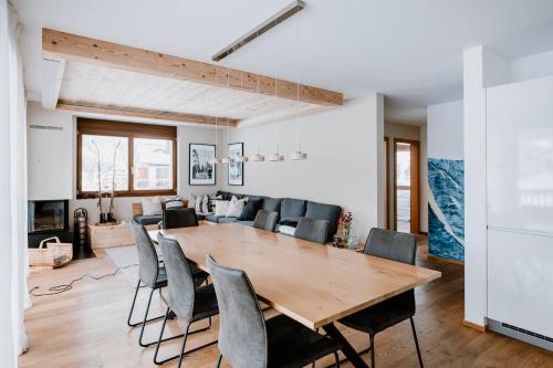 a dining room and living room with a wooden table and chairs at Am Heimberg Skilift - Mullers x Kandahar Suite in Parpan
