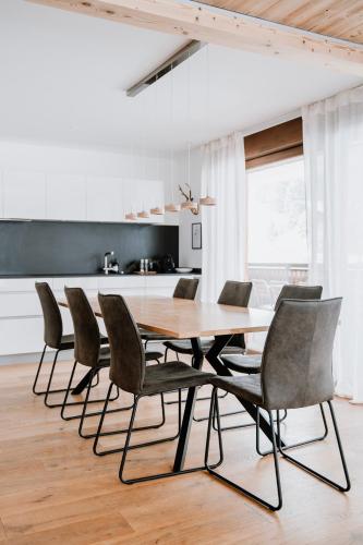 a dining room with a wooden table and chairs at Am Heimberg Skilift - Mullers x Kandahar Suite in Parpan