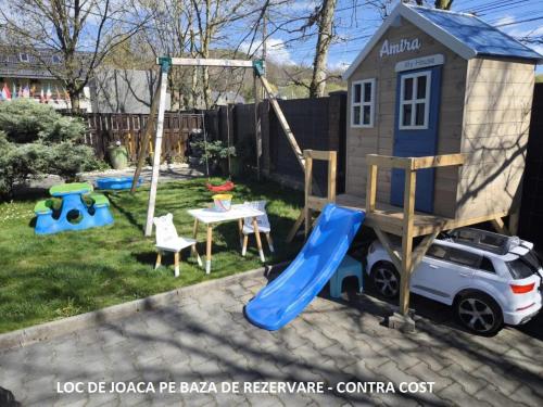 a play house with a slide and a car at Pensiunea Vila Chesa in Corunca
