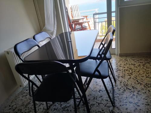 a table and chairs in a room with a balcony at Sea View Apartment with 3 Bedrooms in Amfilochia in Amfilochía