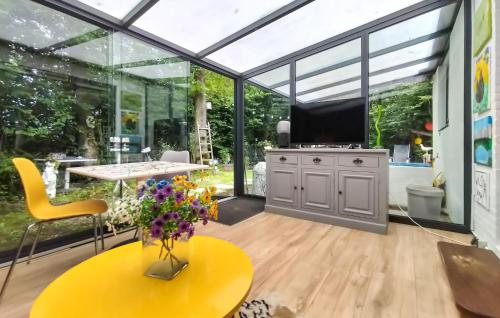 a conservatory with glass walls and a table and a tv at Beautiful Home In Baarland With Wifi in Baarland