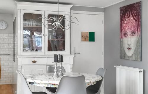 a dining room with a table and a cat on the wall at Beautiful Home In Baarland With Wifi in Baarland