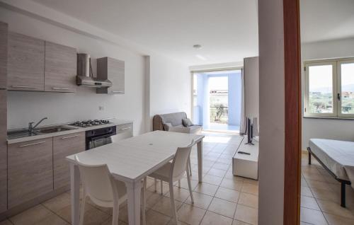 Awesome Apartment In Isca Marina في بادولاتو: مطبخ وغرفة طعام مع طاولة وكراسي