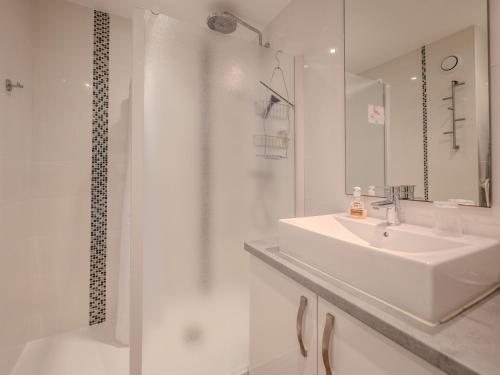 une salle de bain blanche avec un lavabo et une douche dans l'établissement Appartement T2 avec balcon face mer - FR-1-197-132, à Les Sables-dʼOlonne