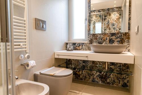 a bathroom with a sink and a toilet and a mirror at Residence AleDen in Vieste