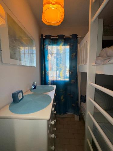 La salle de bains est pourvue d'un lavabo et d'un rideau de douche bleu. dans l'établissement T2 Mer et Soleil avec Terrasse, à Sète