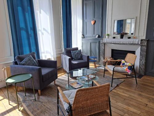 a living room with couches and chairs and a fireplace at Le Logis des Dames in Sedan