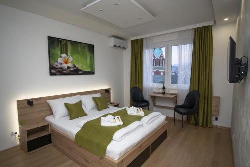 Una habitación de hotel con una cama grande y un escritorio. en Inaya Apartman Free Parking, en Sarajevo