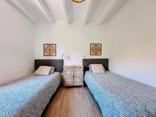 two twin beds in a room with a wooden floor at Cal Moline 2 Estel in Aviá