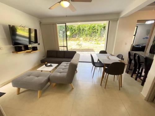 a living room with a couch and a table and chairs at G105-Hermoso apartamento en condominio campestre in La Tebaida