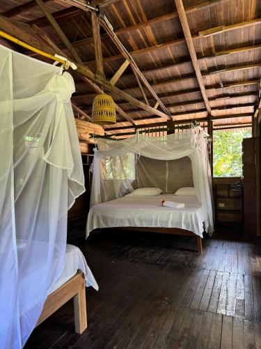 a bedroom with a white bed in a wooden ceiling at Madre Selva Eco Lodge in Nuquí