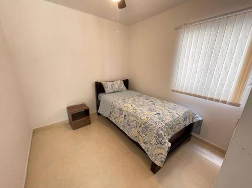 a small bedroom with a bed and a window at G105-Hermoso apartamento en condominio campestre in La Tebaida