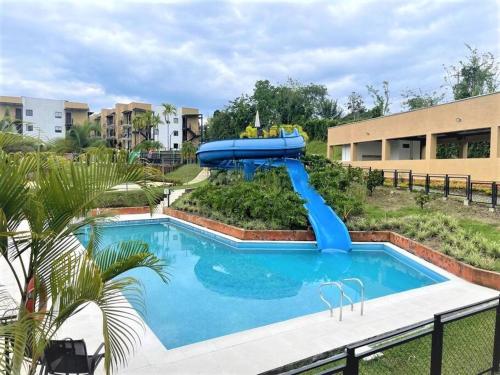 a blue water slide in the middle of a pool at G105-Hermoso apartamento en condominio campestre in La Tebaida