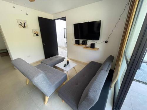 a living room with a couch and chairs and a tv at G105-Hermoso apartamento en condominio campestre in La Tebaida