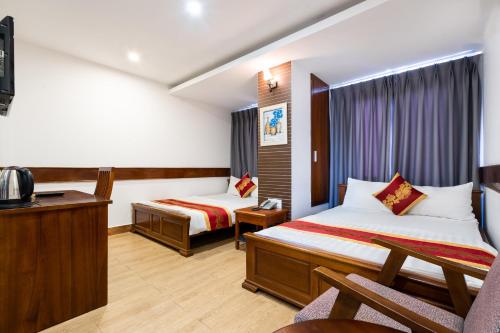a hotel room with two beds and a desk at King Hotel Saigon Airport in Ho Chi Minh City