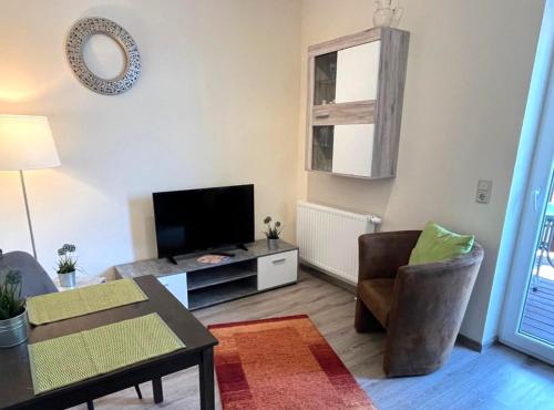 a living room with a flat screen tv and a table at Ferienwohnungen LpP Bad Suderode in Bad Suderode