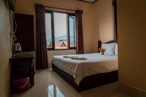 ヴァンヴィエンにあるDokPhut Guesthouseのベッドルーム1室(ベッド1台、大きな窓付)