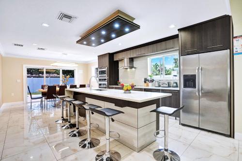 a kitchen with a large island with bar stools at Luxury 4BR & 4BA Villa Heated Pool Minutes To Beach in Hollywood