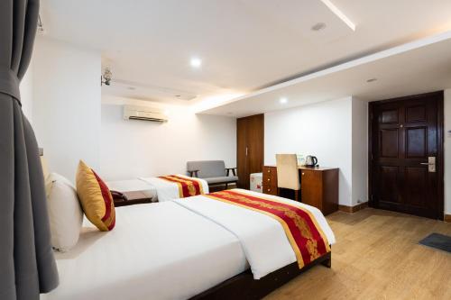 a hotel room with two beds and a desk at King Hotel Saigon Airport in Ho Chi Minh City