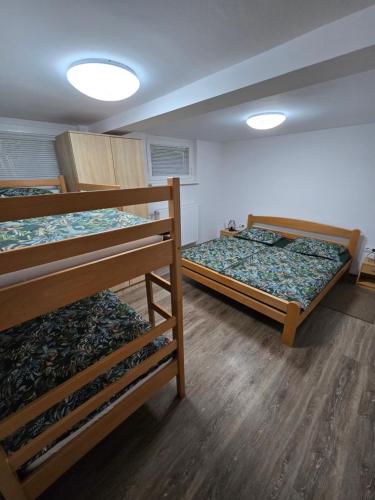 three bunk beds in a room with wooden floors at Apartments Boldin in Bled
