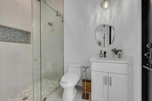 a bathroom with a shower and a toilet and a mirror at Quiet 5-br House Heated Pool And Outdoor Kitchen in Naples