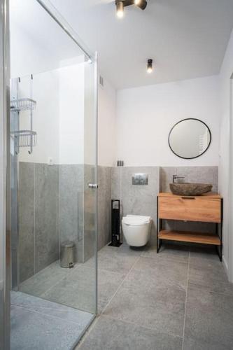 a bathroom with a shower and a toilet and a sink at Golf & Lake House 16 in Naterki